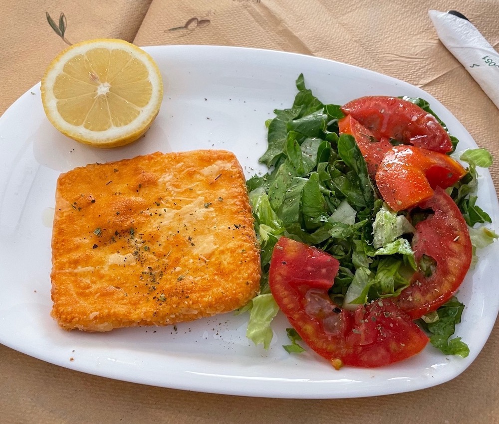 authentic greek saganaki fried cheese with salad and lemon wedge