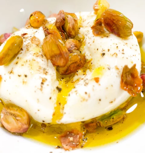 Photo of burrata recipe with olive oil and pistachios on top