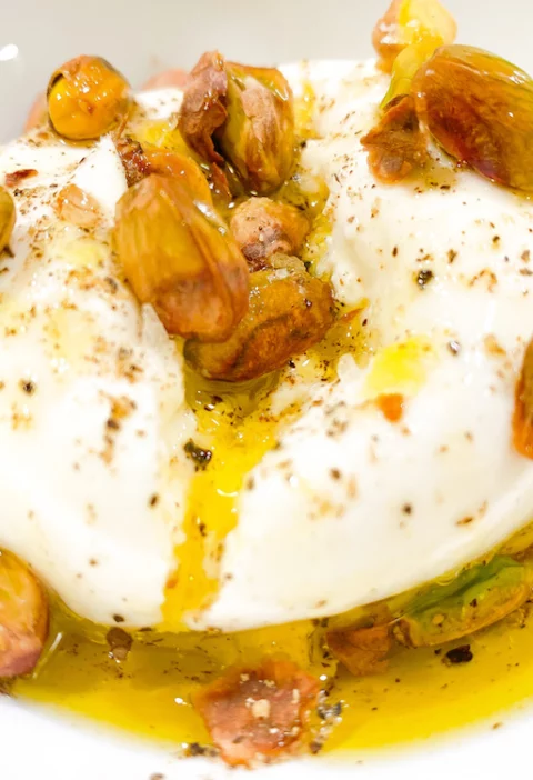 Photo of burrata recipe with olive oil and pistachios on top