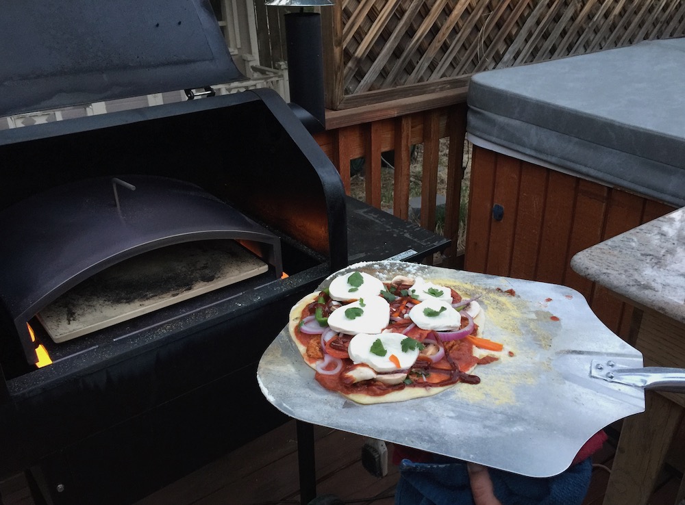 Green Mountain Grills Pizza Oven showing pizza peel going into oven.